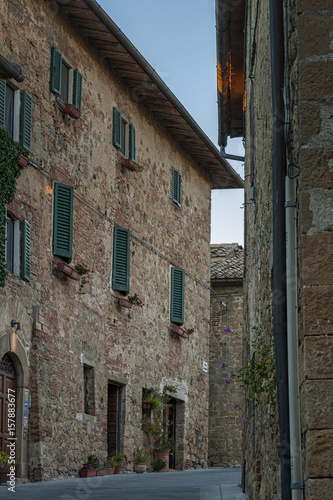 Montichiello - Italy, October 29, 2016:  Quiet street in Montichiello, Tuscany with typical shuttered windows and paved streets. Monticchiello is the only fraction of the municipality of Pienza, in th