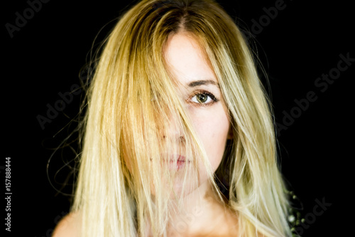 Portrait of a beautiful woman shaking her hair on black background