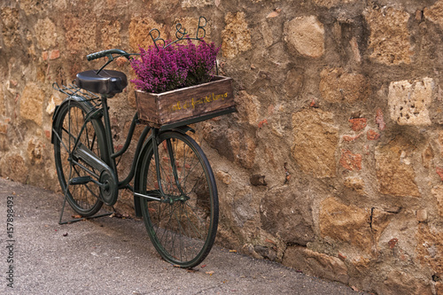 Montichiello - Italy, October 29, 2016: A beautiful bicycle with flowers in a quiet street in Montichiello, Tuscany  