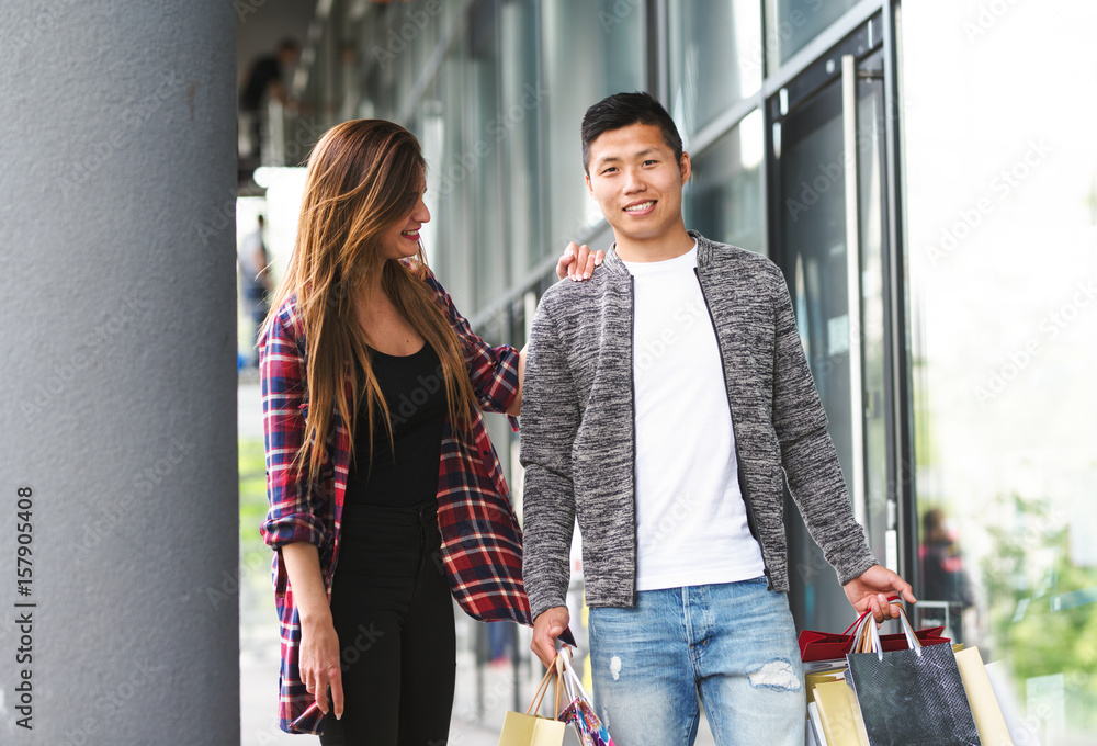 happy interracial couple - boyfriend and girlfriend shopping happy interracial couple - boyfriend and girlfriend shopping