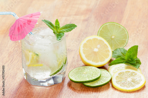 A glass of cold water with lemon and lime, ice cubes and mint leaves © Colored emotions