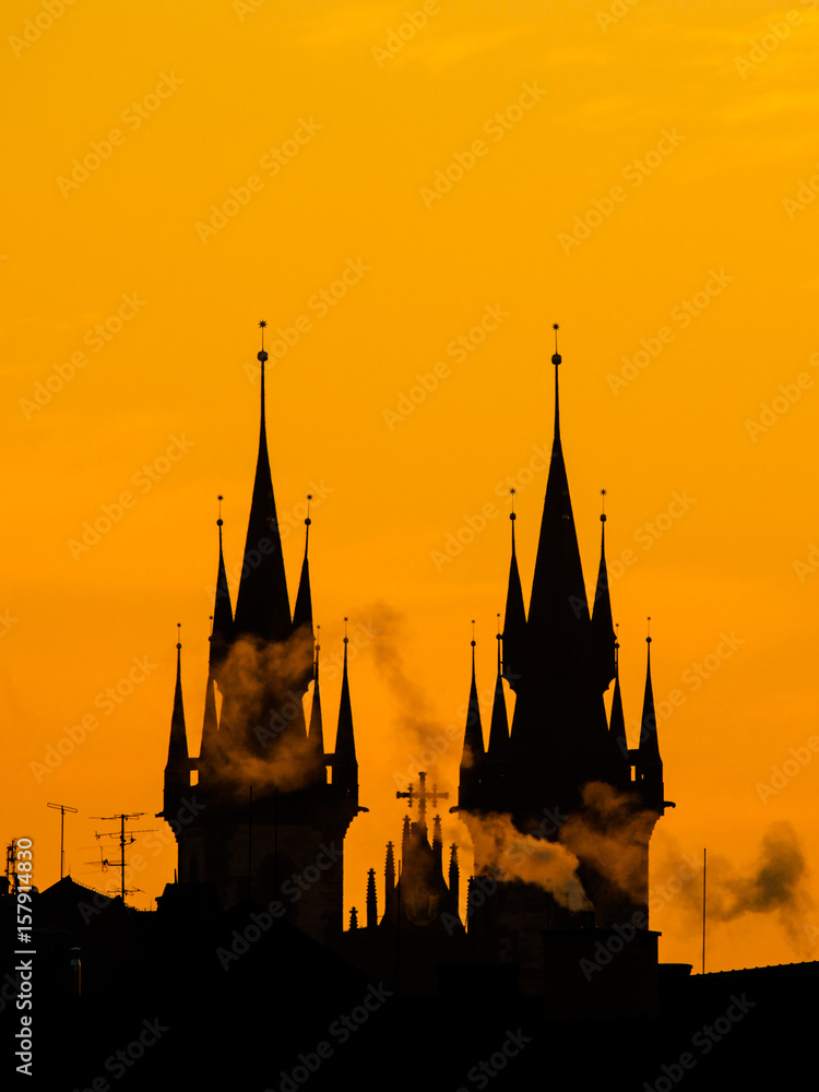 Silhouette of two towers of Church of Our Lady before Tyn in morning Prague, Czech Republic. Contrast black controur and orange sky.