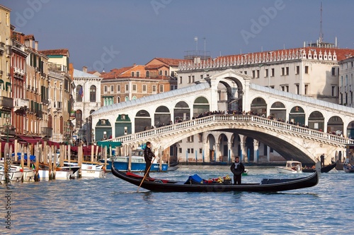 A gondola crossing the Grand Canal right in front of the Rialto Bridge, one of the most recognizable Venetian landmarks Venice, Veneto Italy Europe © ClickAlps