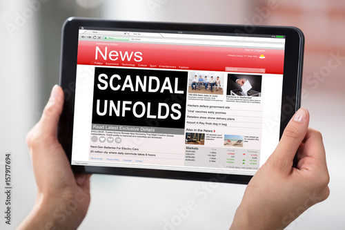 Foto Digital Tablet With A Screen Showing Unfolds Scandal News