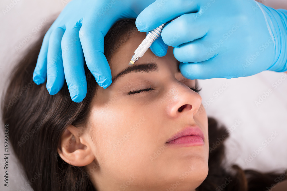 Cosmetologist Applying Permanent Make Up On Eyebrows
