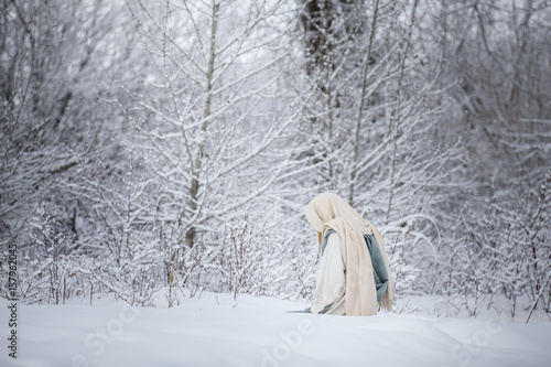 Jesus Christ kneeling and praying in the snow. 