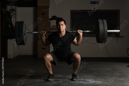 Strong man lifting a barbell at the gym