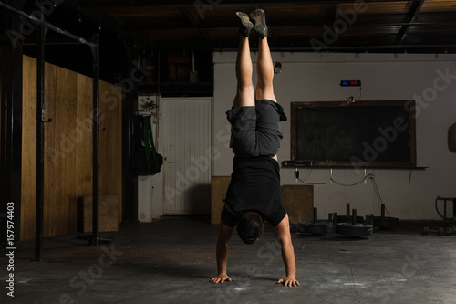 Fotótapéta Strong man doing a handstand at the gym