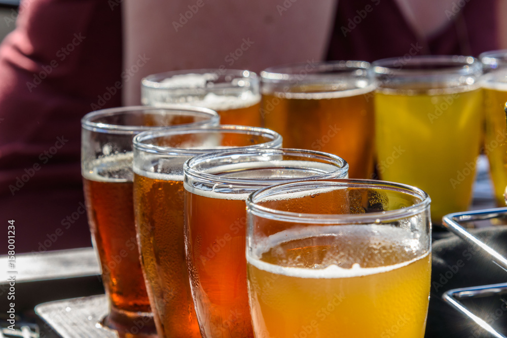 Beer sampler at outdoor beer garden with woman's arm in background