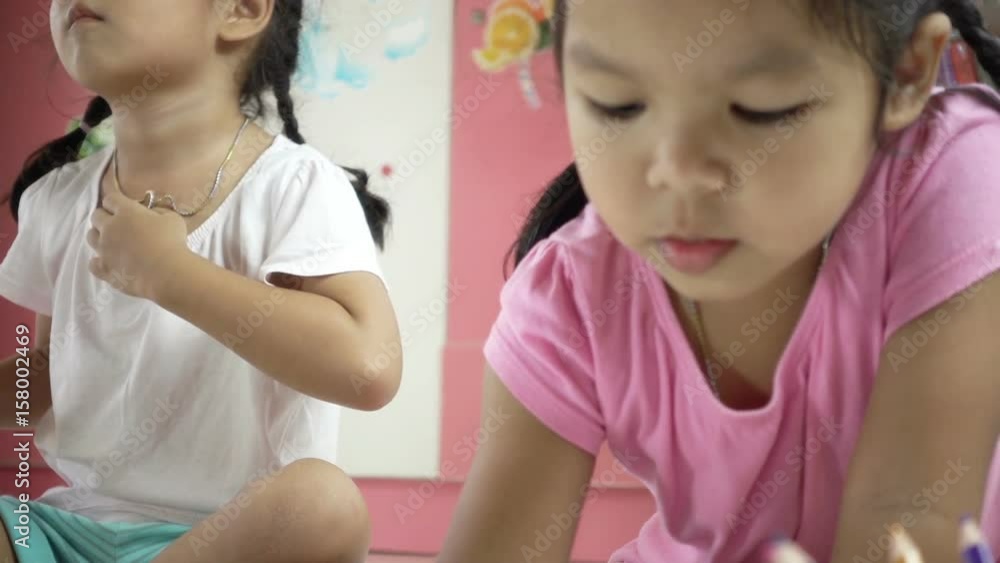 Slow motion of cute asian little girl pay attention to paint her picture with crayon Slow motion of cute asian little girl pay attention to paint her picture with crayon