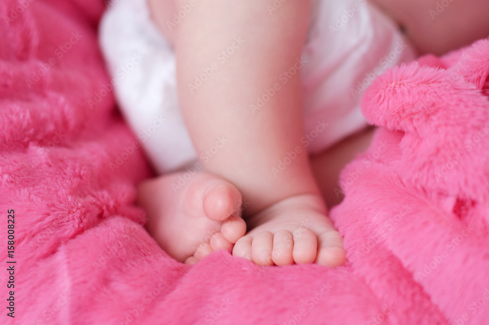 Newborn feet closeup, baby girl heels on pink background of mohair blanket, soft and cute Newborn feet closeup, baby girl heels on pink background of mohair blanket, soft and cute