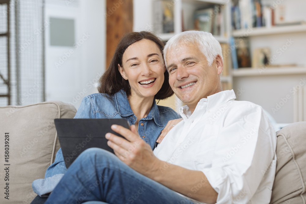 Mature couple at home websurfing with tablet