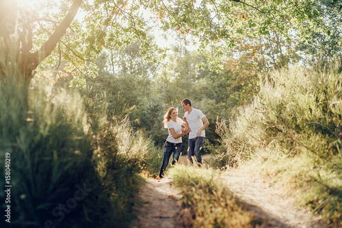 Cheerful young couple walking throught the path in the summertime © Vladimir