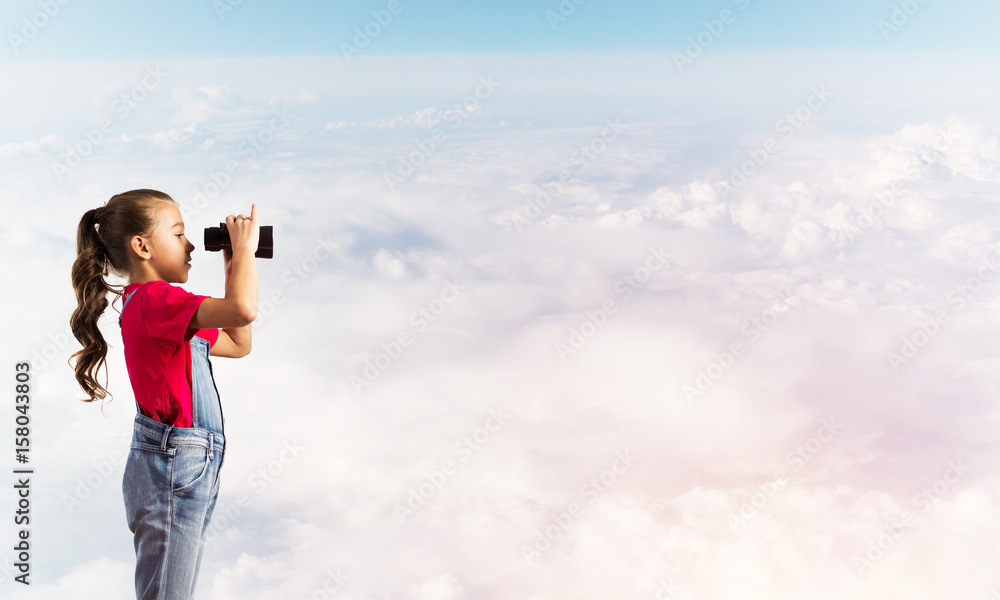 Concept of careless happy childhood with girl looking in binoculars Concept of careless happy childhood with girl looking in binoculars