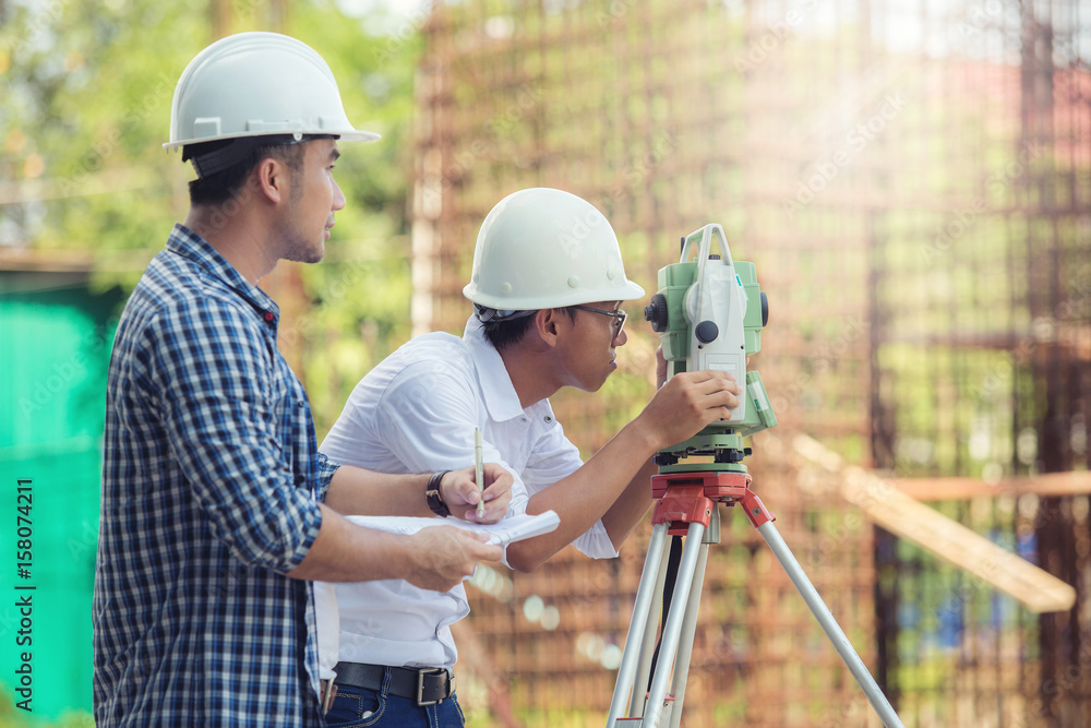 Civil Engineers At Construction Site and A land surveyor using an altometer Civil Engineers At Construction Site and A land surveyor using an altometer