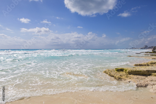 Seascape on a sunny summer day in the Caribbean sea shore. Blue sky with some clouds and white sand beach and turquoise water.