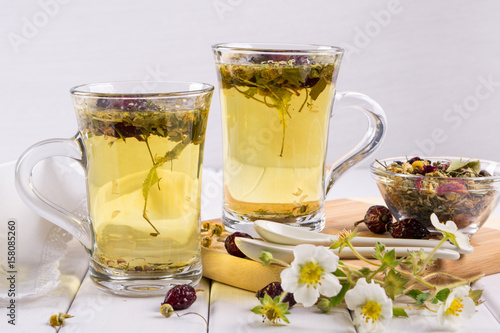 Tea of useful herbs and flowers. Two glass cups. Tea ingredients
