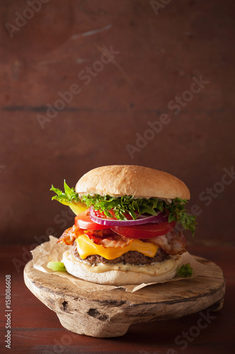 bacon cheese burger with beef patty, tomato and onion