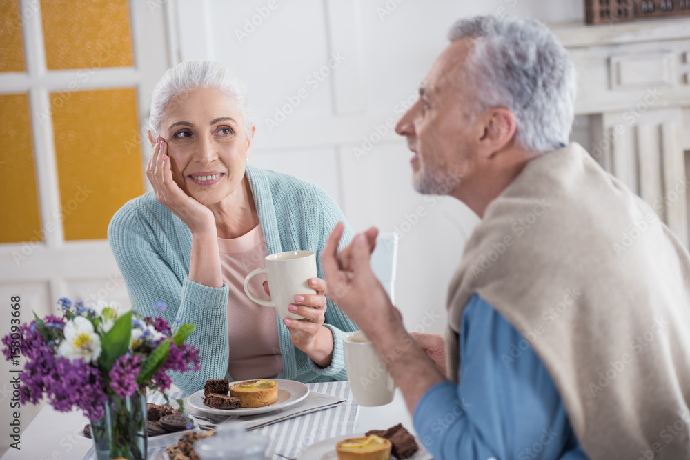 senior couple talking and drinking tea during breakfast at home senior couple talking and drinking tea during breakfast at home