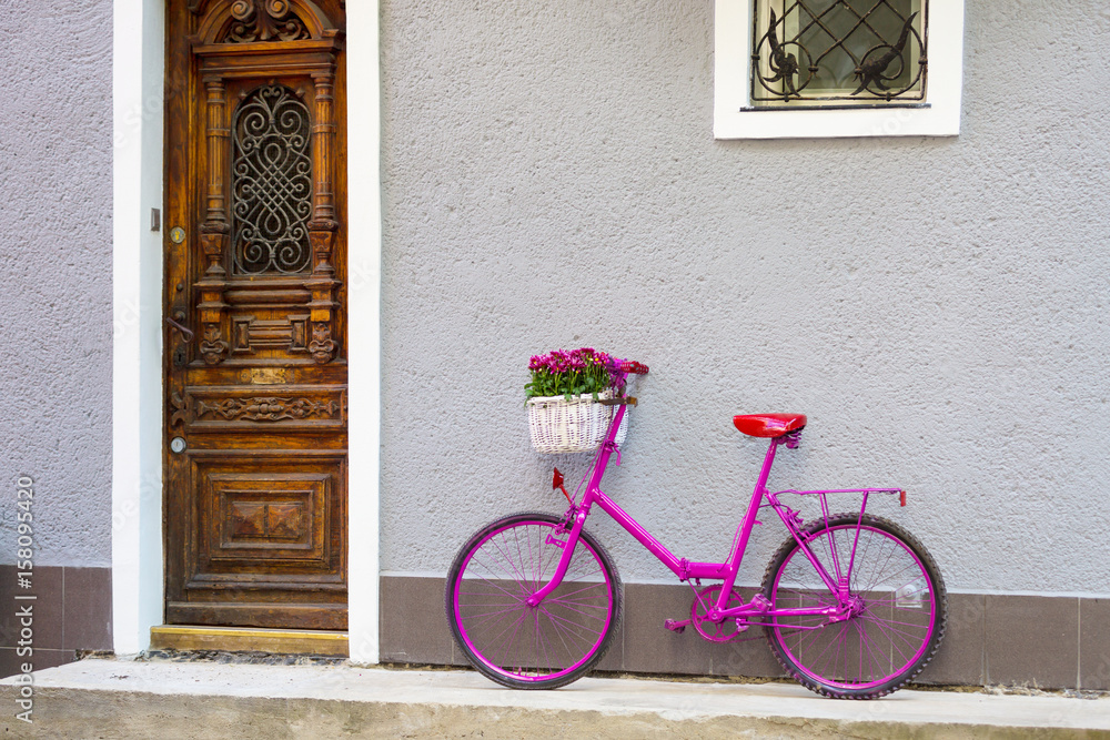 pink bike standing by the wall