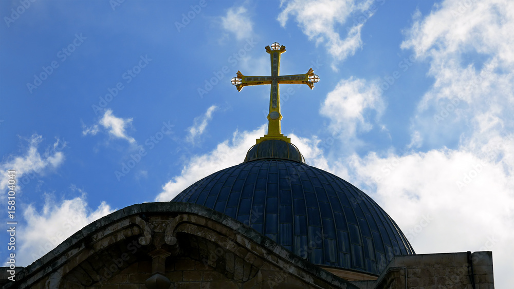 Golden cross over Temple of the Holy Sepulcher church in Jerusalem. The Holy Sepulchre Church is the most sacred place for all Christians in the world.