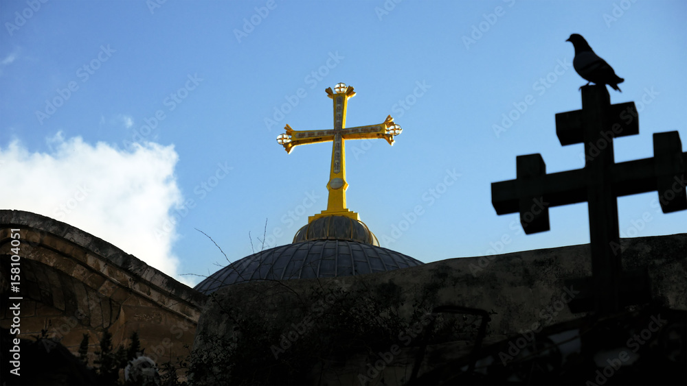 Golden cross over Temple of the Holy Sepulcher church in Jerusalem. The Holy Sepulchre Church is the most sacred place for all Christians in the world.