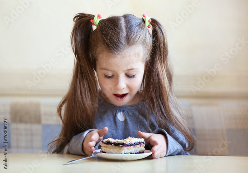 Cute little girl eating tas...