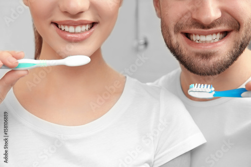 Young happy couple brushing...