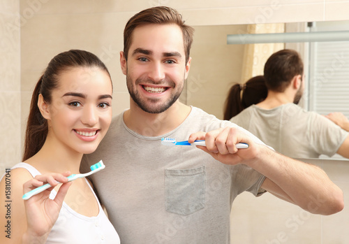 Young happy couple brushing...