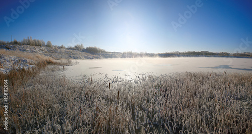Winter sun over the lake grass © kichigin19