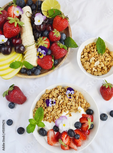Yogurt with granola and fruits, blueberries, strawberries, cherry, apple, banana, healthy breakfast