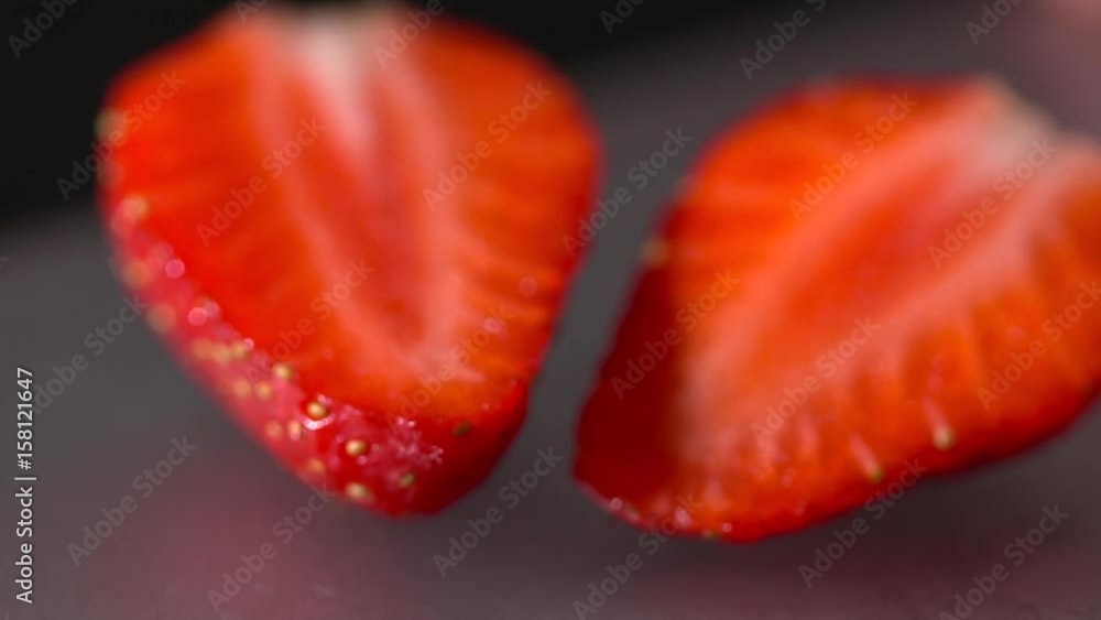 Closeup of sliced strawberry on the black background slow motion Closeup of sliced strawberry on the black background slow motion