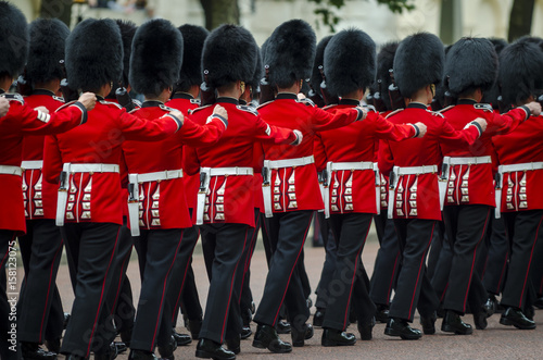 Stampa su tela Soldiers in classic red coats march along The Mall in London, England in a grand