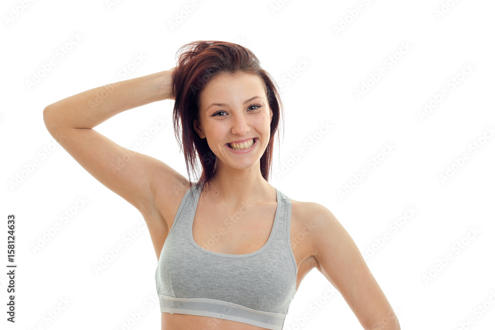 horizontal portrait of joyous beautiful brunette that stands in a gray top looks straight and laughs horizontal portrait of joyous beautiful brunette that stands in a gray top looks straight and laughs