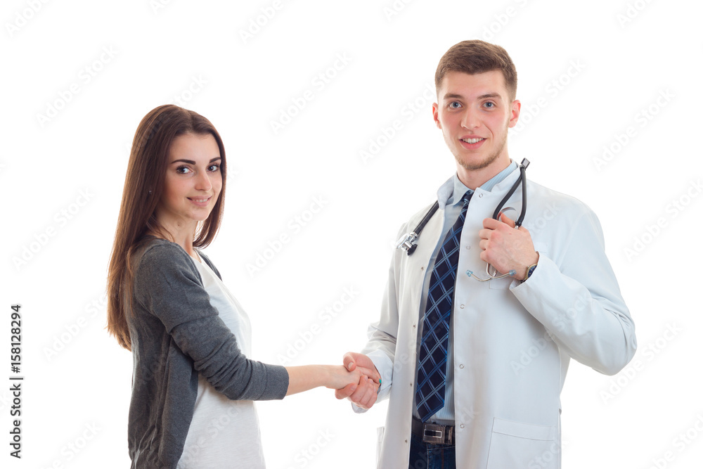 young beautiful girl shakes the hand of the doctor and a close-up of a smiling young beautiful girl shakes the hand of the doctor and a close-up of a smiling