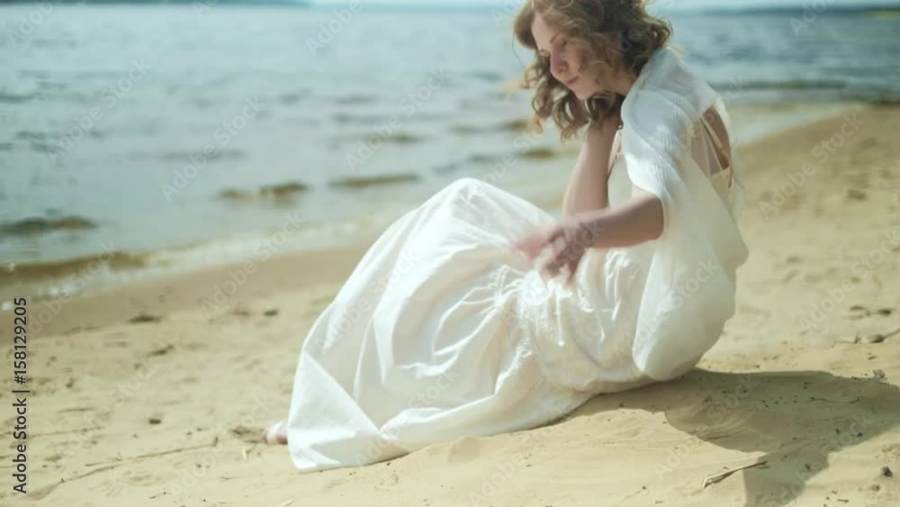 Woman In white dress staying on a beach with flower at the sunny day 4k Woman In white dress staying on a beach with flower at the sunny day 4k