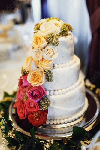 White wedding cake decorated with green and pink flowers