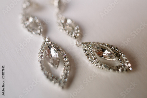 Crystal earrings lie on white table