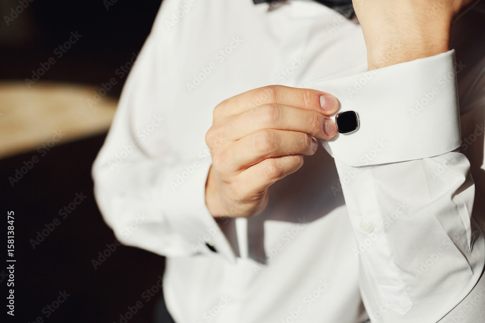 Man fixes cufflinks on the sleeves Man fixes cufflinks on the sleeves