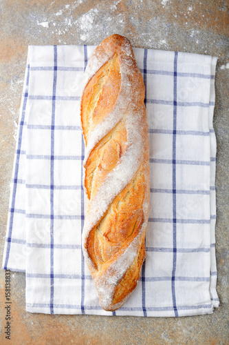 One fresh crunchy Baguette on slate