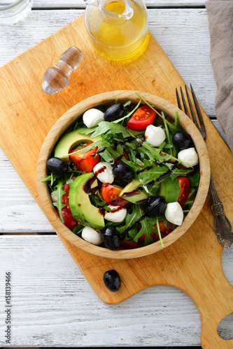Salad with avocado, tomatoes, olive, mozzarella and arugula