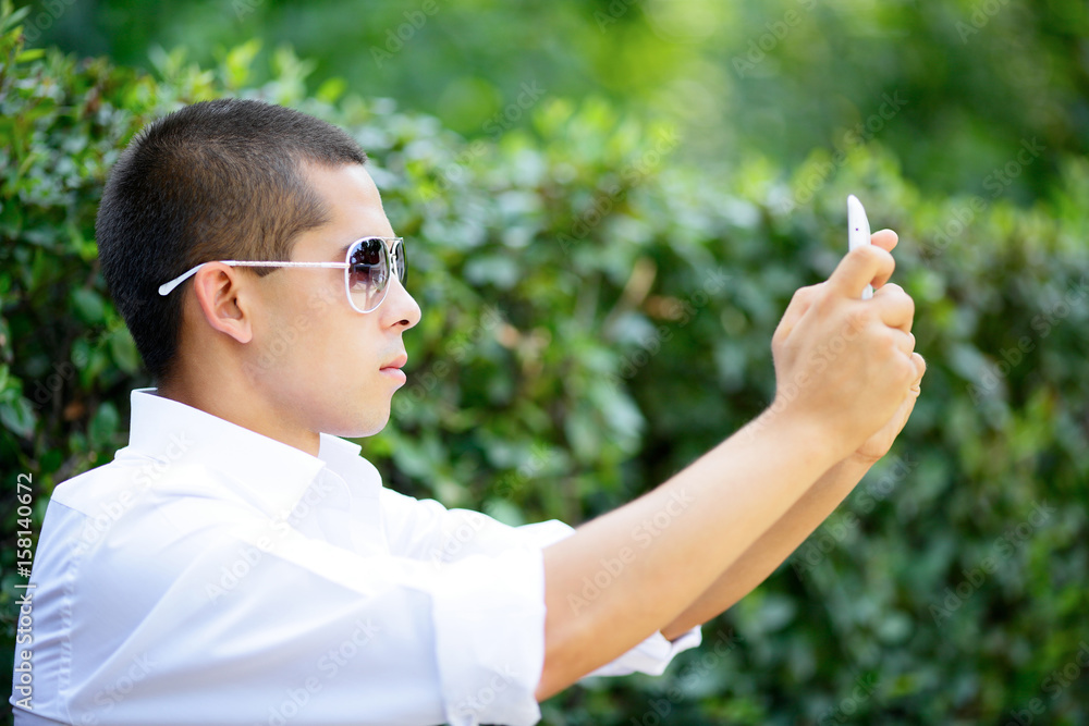 Young man in sunglasses shoot through tablet Young man in sunglasses shoot through tablet