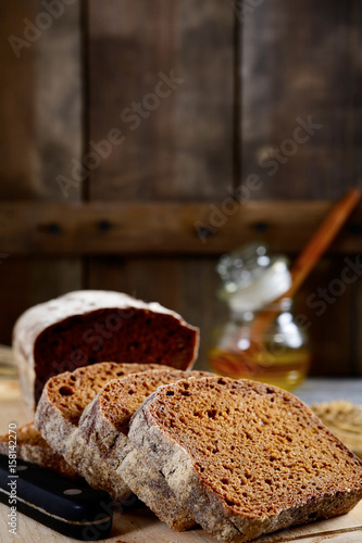 Slices of rye bread and honey on a wooden background