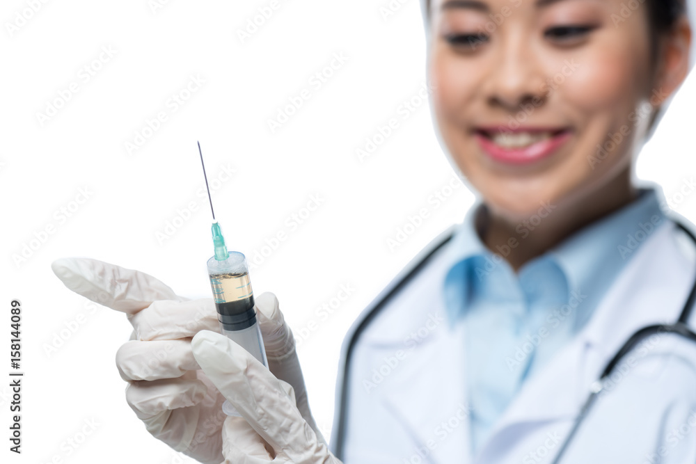 selective focus of smiling doctor in protective gloves holding syringe isolated on white selective focus of smiling doctor in protective gloves holding syringe isolated on white