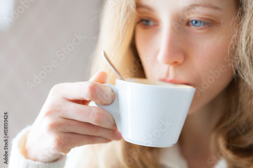 Young woman drinking coffee. Cup of hot beverage