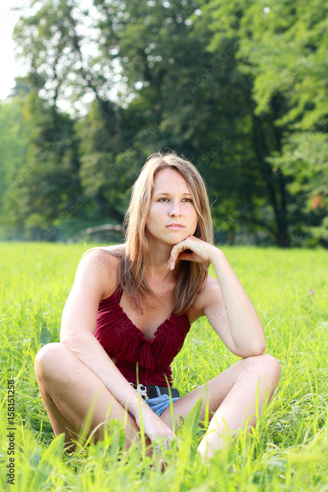 Beautiful young woman relaxing on green grass Beautiful young woman relaxing on green grass