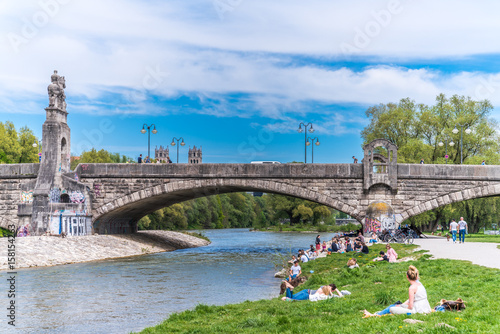 Isar in München an der Wittelsbacherbrücke mit Erholungssuchenden am Isarufer photo