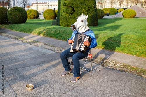 Fotografi Man with a horse head street musician playing the accordion outdoors, funny pran