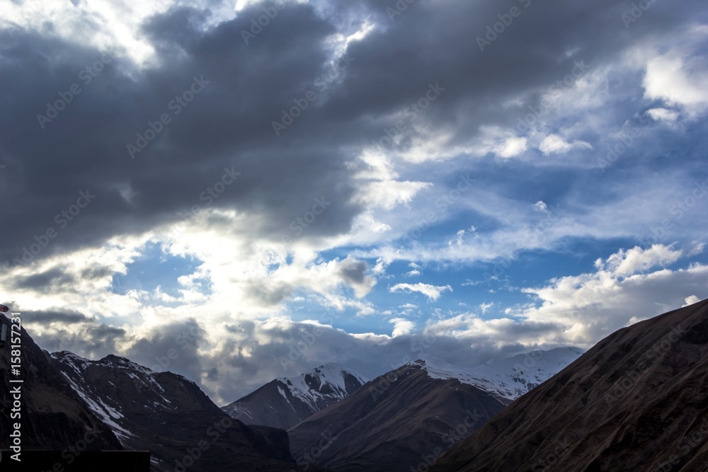 Горный пейзаж, красивый вид на живописное ущелье, высокие снежные склоны, облачное небо над горами, природа Кавказа, Грузия