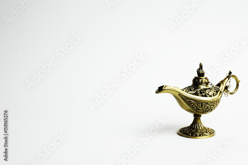 Close up of gold decorated magic lamp isolated in white background.
